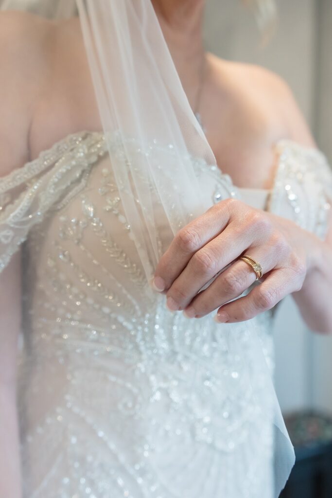 Detail shot of wedding ring, dress and veil