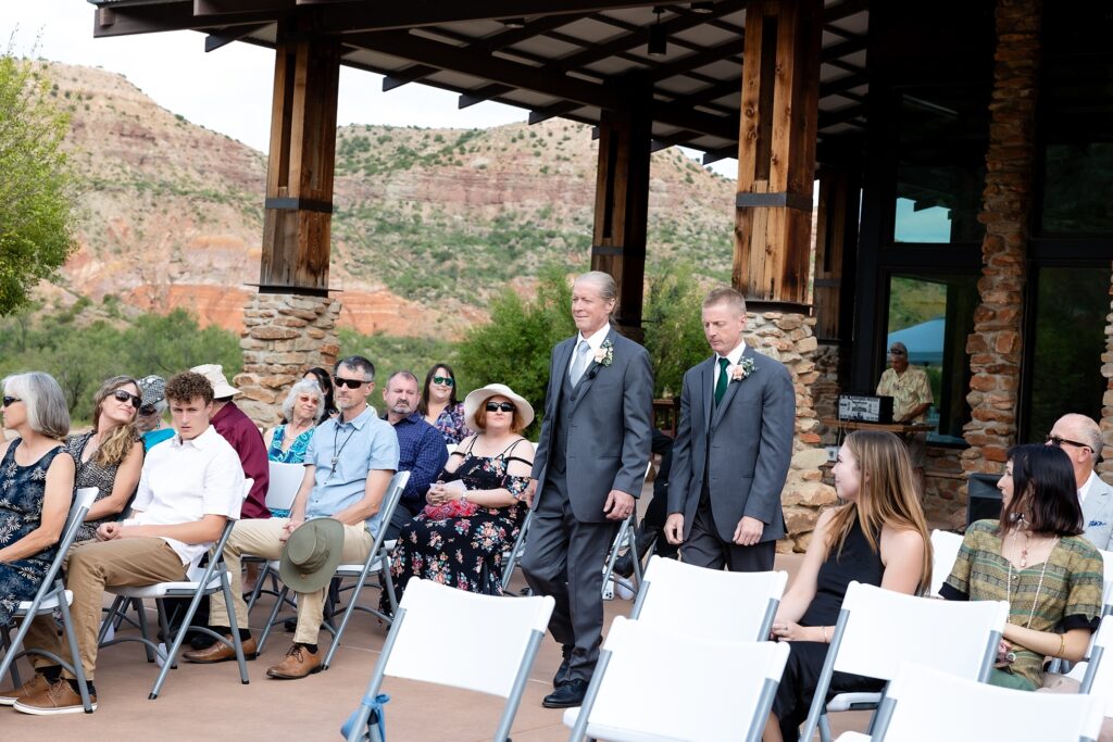 Two men walking at the outdoor wedding in Mack Dick Pavilion in Palo Duro State Park, Canyon TX