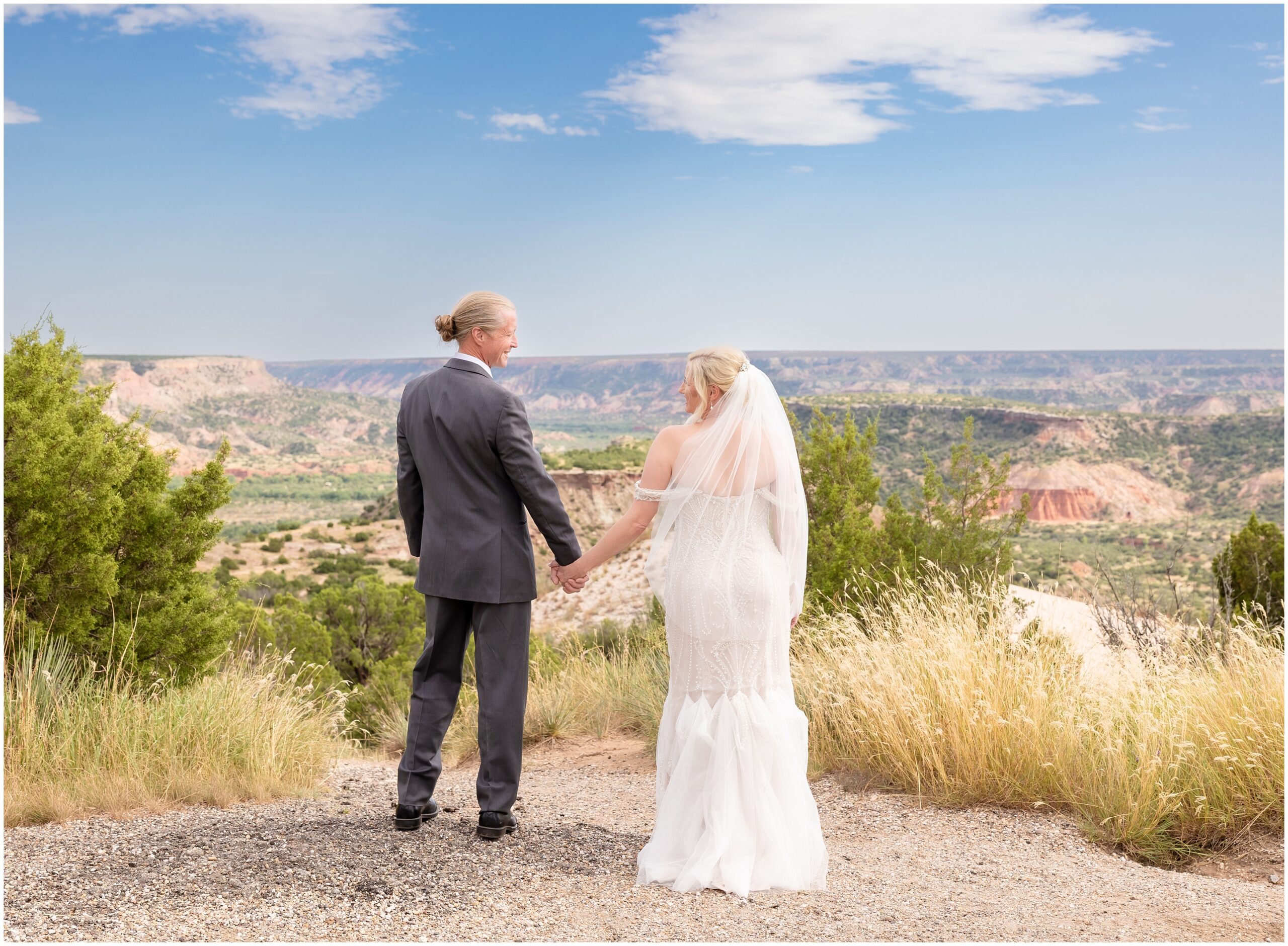 Bride and groom looking at each other facing toward Palo Duro Canyon lookout